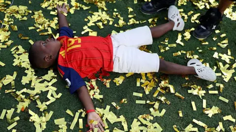 Maja Hitij - FIFA / Getty Images Keyne lies on the ground surrounded by golden confetti 