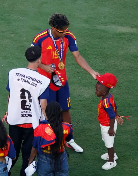 Reuters Lamine Yamal puts a cap on his younger brothers head following his World Cup win
