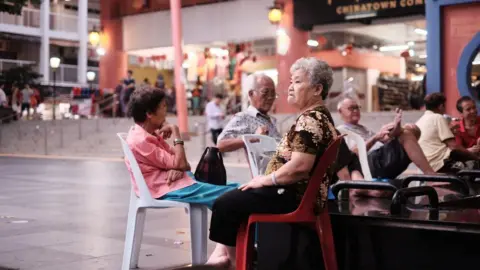 A Chinese box office hit sparks a debate about identity in Singapore Getty Images Old people sitting on plastic chairs in an open space