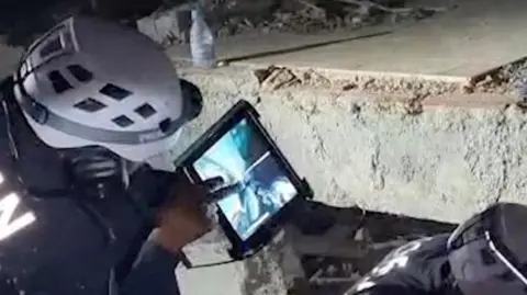 Jordan Public Security via Reuters A Jordanian team works to rescue a child trapped under rubble following earthquakes in Venezuela.