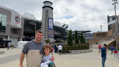 Eben Pingree Eben Pingree holds a black hoodie in his right hand as he stands with his left arm around his son Cole in front of the Boston Stadium