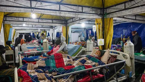 AFP via Getty Images Earthquake victims are treated in a temporary medical tent due to fears of aftershocks, in front of the Ruteng hospital in Ruteng, Manggarai