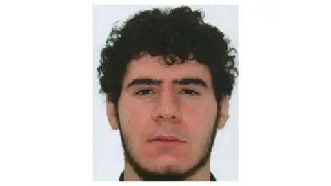 Polizei Berlin The 21-year old suspect identified by police as Abdul B. in a public call for his arrest, after a vehicle rammed down the crowd near Berlin's Pride CSD celebrations on Saturday evening, killing one person and wounding several, in this undated handout photo released by Polizei Berlin on July 26, 2026. 