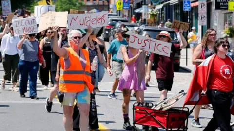 Reuters Protesters holding anti-ICE signs in Maine