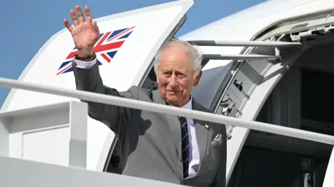 Reuters Britain's King Charles III waves as he boards his plane at Joint Base Andrews in Maryland.