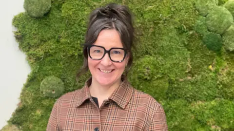 Back to books - Sweden's schools give up digital learning Maddy Savage Jannie Jeppesen smiles at the camera, wearing a patterned top and thick framed, black glasses