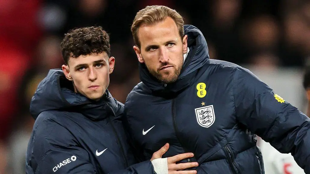 England beaten by Japan in final match before World Cup squad is named Phil Foden and Harry Kane after the final whistle at Wembley, with both wearing blue England team coats and Foden with his right hand across Kane's chest