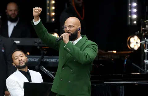 Getty Images Award-winning rapper Common performs onstage while John Legend plays piano at the Obama Presidential Center in Chicago
