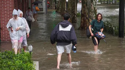 China evacuates one million from homes as massive storm arrives Getty Images Residents wade through flooded streets in Shanghai