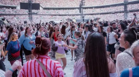 Harry Styles receives Guinness World Record for longest Wembley Stadium run Live Nation/PA Fans, many female and wearing sparkly skirts and dresses, can be seen dancing in the standing area of Wembley Stadium during Styles' concert on Saturday. Thousands of other people can be seen in the background