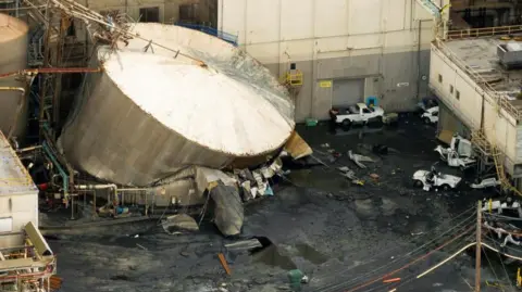 Reuters The ruptured tank, with crushed cars in the foreground