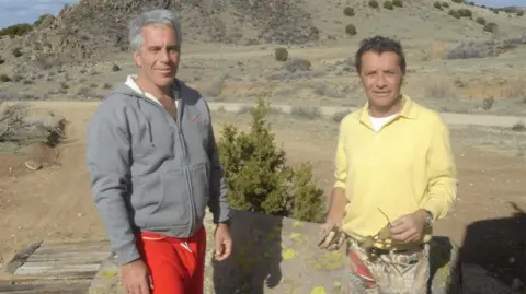 US Department of Justice  Jeffrey Epstein in a tracksuit top and Jean-Luc Brunel, with sunsglasses in his hand, pose in an undated photo released by the U Department of Justice