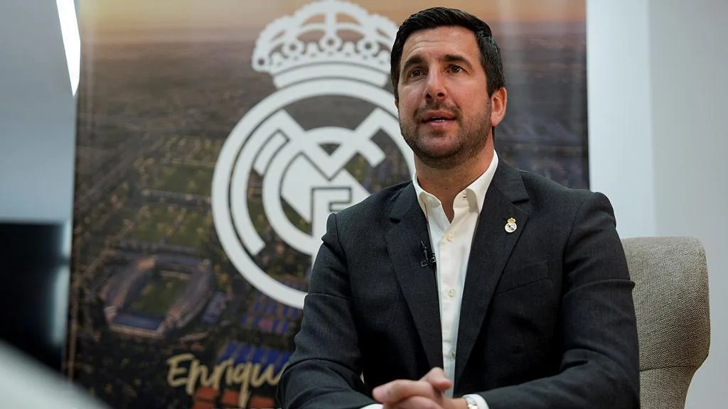 Spanish businessman Enrique Riquelme sits in front of a Real Madridn badge ahead of the club's presidential election, in which he is a candidate