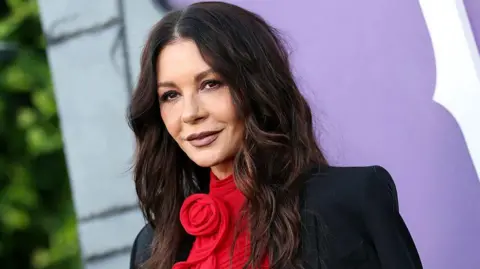 Getty Images Catherine Zeta Jones in a red dress and black jacket