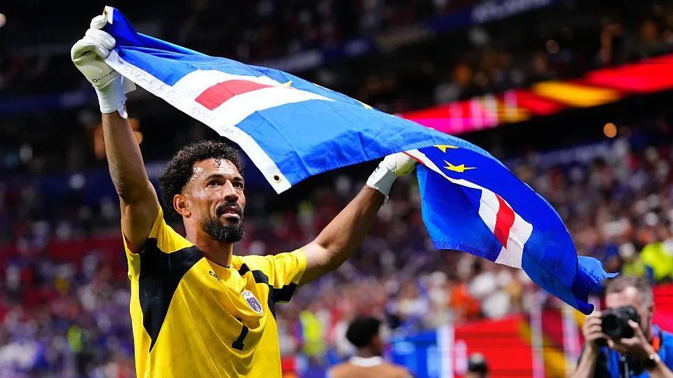Vozinha holds up a Cape Verde flag