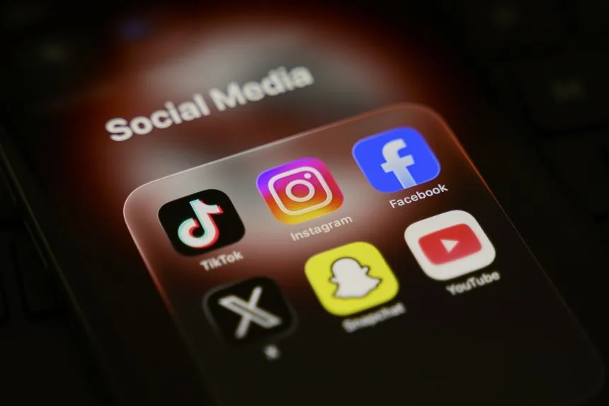 A smartphone displays a folder of social media applications, including TikTok, Instagram, Facebook, X, Snapchat, and YouTube, in Creteil, France, on March 31, 2026.
