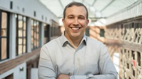 Businesses scramble to get noticed by AI search HubSpot Smiling Kipp Bodnar and with his arms folded, Kipp Bodnar wears a grey shirt.
