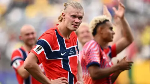 Reuters Dressed in the traditional red jersey, Norway's Erling Haaland has his hands on his hips as he celebrates after the match as Norway qualify for the quarter finals of the World Cup. 