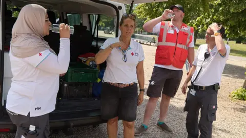 AFP via Getty Images Red Cross volunteers provide water and assistance to homeless and vulnerable people on the street during a Code Red heat alert on June 26, 2026 in The Hague, Netherlands