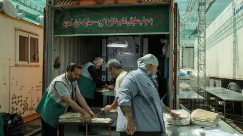 Reuters Four men preparing bread in a cooling area