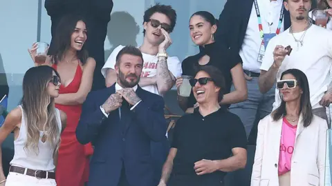 Getty Images (Bottom from L) English former footballer David Beckham, singer and designer Victoria Beckahm, US actor Tom Cruise, (top from L) Jackie Apostel, Cruz Beckham, Kim Turnball and Romeo Beckham attend the 2026 World Cup football tournament
