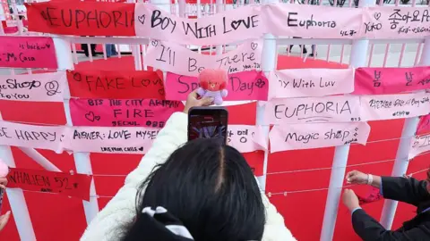 The BTS fans losing thousands as scammers cash in on comeback tour 'ticket war' Getty Images Fans of K-pop boy band BTS share a moment ahead of the comeback concert of K-pop boy band BTS on March 20, 2026 in Seoul, South Korea.