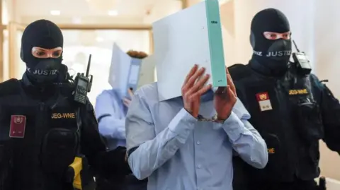 Man jailed for 15 years over plot to attack Taylor Swift concert in Vienna Reuters Two armed Austrian security personnel in masks flank a suspect, identified only as Beran A. The suspect is seen wearing a blue shirt and carrying a ring binder in front of his face. Photo: 28 May 2026