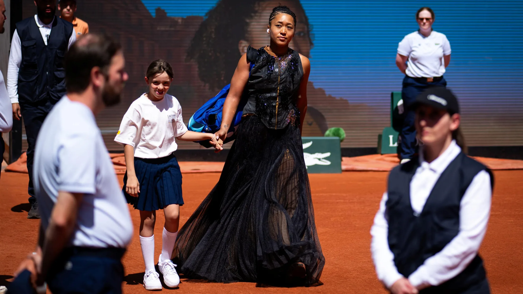 Naomi Osaka arrives on court in black gown