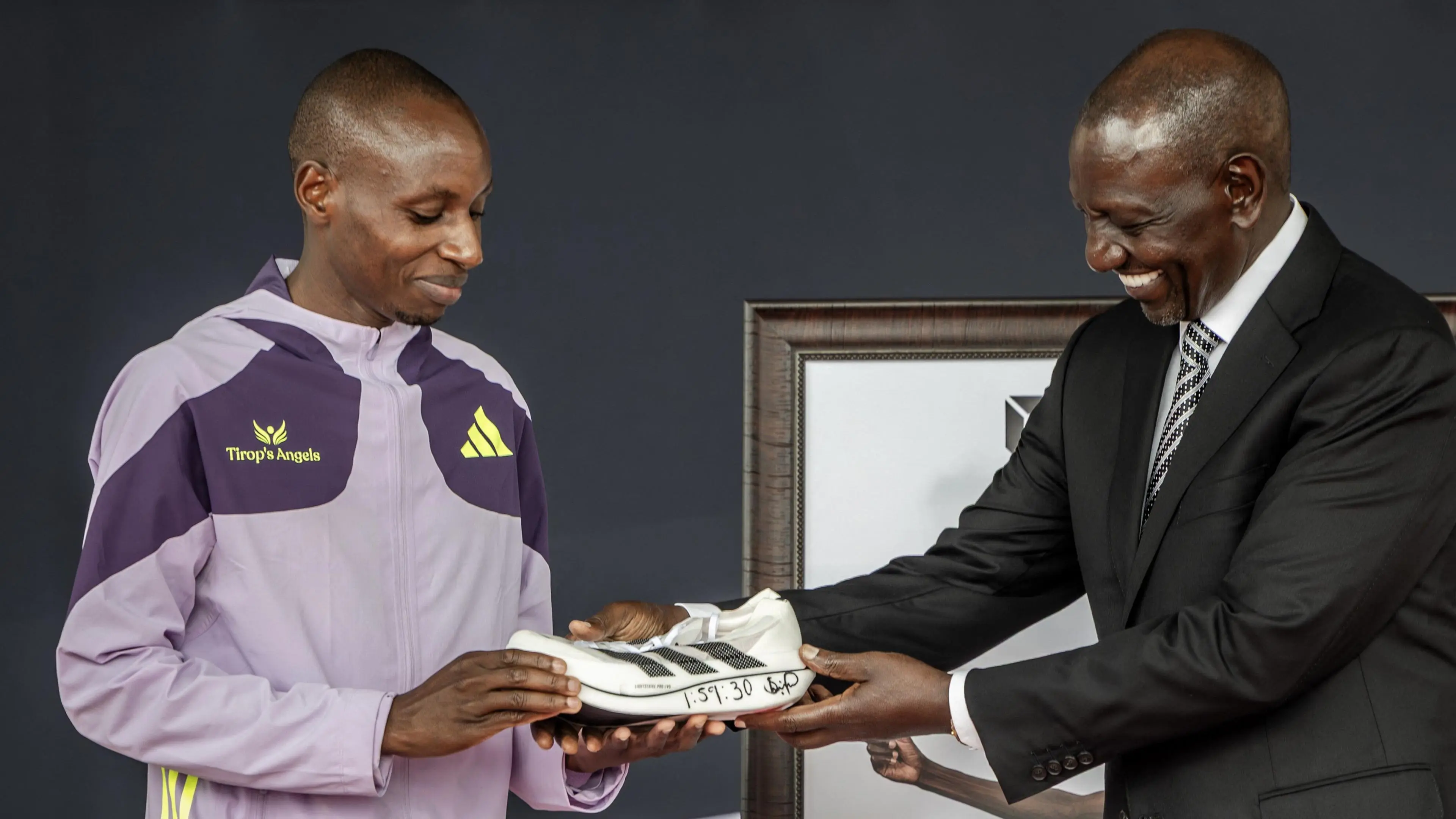 Kenyan marathon runner Sebastian Sawe giving one of the shoes he used to break the world record at the London Marathon to Kenya's President William Ruto