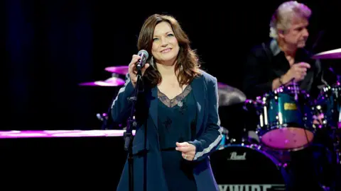 'Cancel it', Trump says after artists drop out of US Freedom 250 festival Getty Images A woman with wavy brown hair in a black pant suit smiles in front of a microphone
