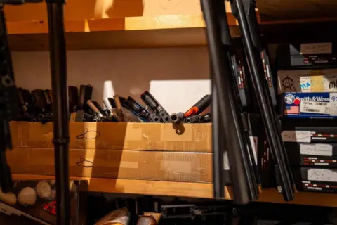 Ex-Canada MP arrested after police seize 439 guns and antique cannon from his home RCMP Firearms and ammunition are store on shelves in what appears to be a closet in a Dauphin, Manitoba home.