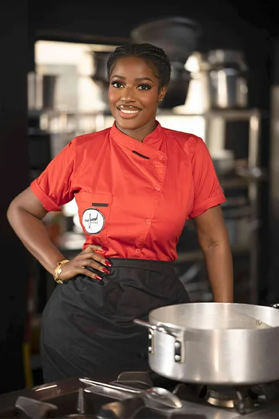 Hilda standing by a cooking pot