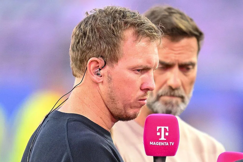 Julian Nagelsmann holding a microphone and standing next to Jurgen Klopp