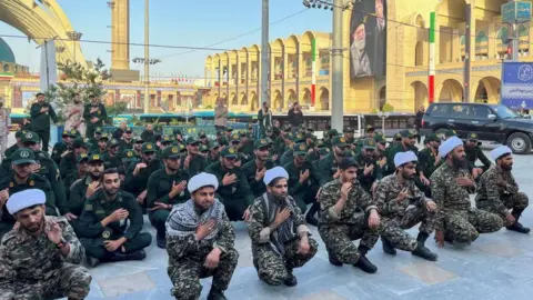Reuters About 50 members of the Basij paramilitary on their knees with their hands on their chests in respect of the late Ayatollah Ali Khamenei
