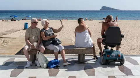 Spain's visitor numbers hit new highs as tourists avoid Middle East AFP via Getty Images Tourists next to the main beach in Benidorm