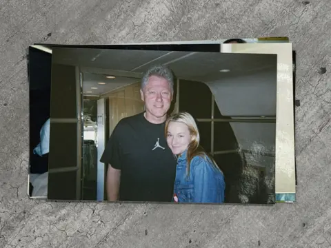 'He liked the fear in our eyes', Epstein survivors tell BBC Chauntae Davies Bill Clinton, an older man with short grey hair, stands close to a young woman, Chauntae Davies. Clinton is in a black short-sleeve t-shirt that has the Air Jordan logo on it. Davies is wearing a light-washed jean jacket. They are inside a plane.