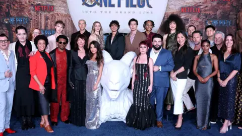 Getty Images The cast of One Piece stand at the premiere in floor length ballgowns and ties 