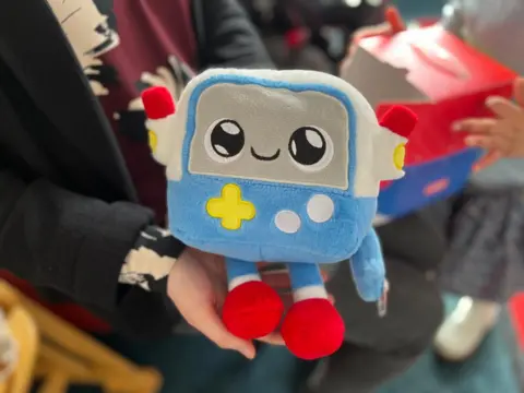 AI toys for young children need tighter rules, researchers warn Gabbo, a cuddly toy, is held in somebody's hands. Gabbo is soft-textured, like a teddy bear, but looks like a robot.