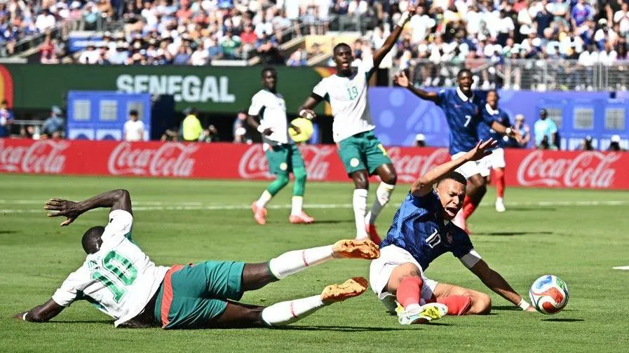 Kylian Mbappe and Sadio Mane challenge for the ball inside the penalty area during France's game with Senegal at the World Cup