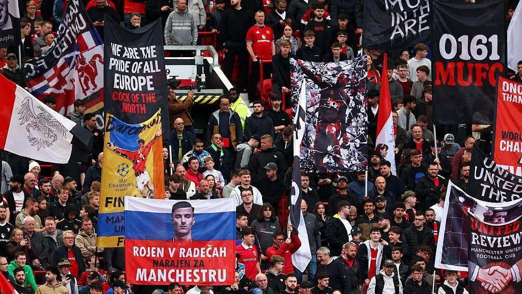 Banners are held by Manchester United fans in the Stretford End during a Premier League match