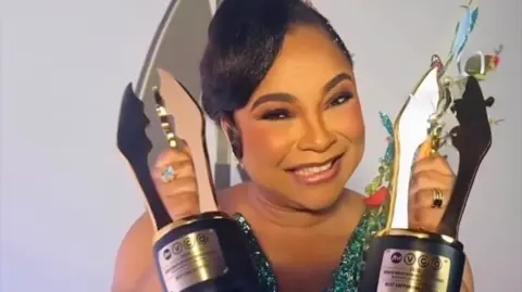 Dress made from 500 loaves stuns Africa Magic Viewers' Choice Awards Ibrahim Suleiman Linda Ejiofor, in a shining blue dress, holds her trophies.