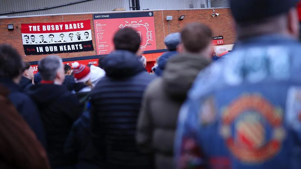 Fans walk towards Old Trafford ahead of a Premier League match