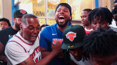 REUTERS/Shannon Stapleton Fans celebrate as they watch the match on a phone along 42nd Street in Times Square, on the day of Game 5 of the NBA Finals  