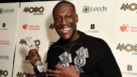 Getty Images Stormzy backstage smiling with Mobo awards 
