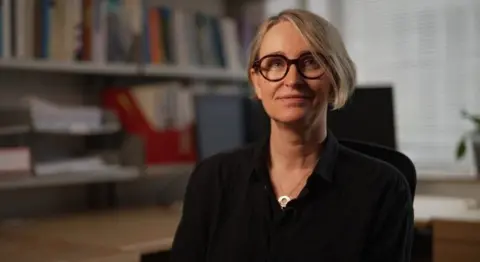 Smacking children could lead to lower GCSE grades, study suggests Lead researcher, associate Prof Anja Heilmann sitting down, wearing a black top with a silver necklace
