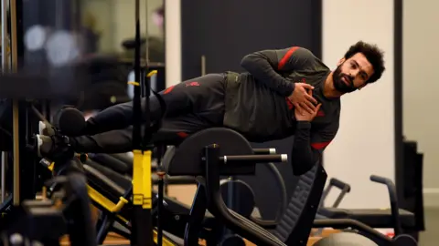 Ice baths, almond milk, meditation and a 'house like a hospital': The secrets of Salah's success Getty Images Mo Salah appears horizontal in a gym as he practices an exercise to strengthen his core. He is wearing a tracksuit and his hips are resting on a curved piece of gym equipment. He has his hands folded across his chess and a calm expression on his face.