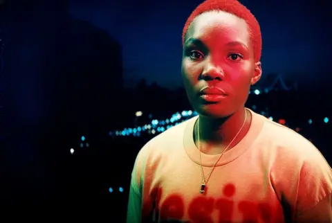 Arlo Parks: 'I got out of my head and into my body' Joshua Gordon Arlo Parks is athed in red light, as she poses against the soft-focus lights of a city at night-time