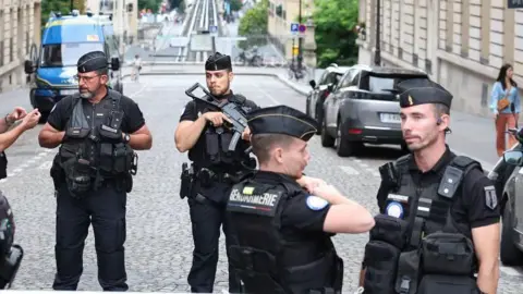AFP via Getty Images Armed, uniformed police on a street in Paris