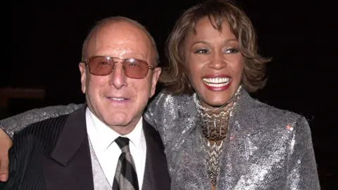 Clive Davis, music mogul behind Whitney Houston and Bruce Springsteen, dies aged 94 Getty Images Clive Davis in a black suit and Whitney Housten in a silver jacket with sequins smiling at the camera