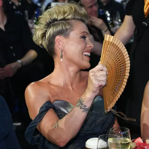 Getty Images Pink fans herself while seated at the Silver Clef Awards 